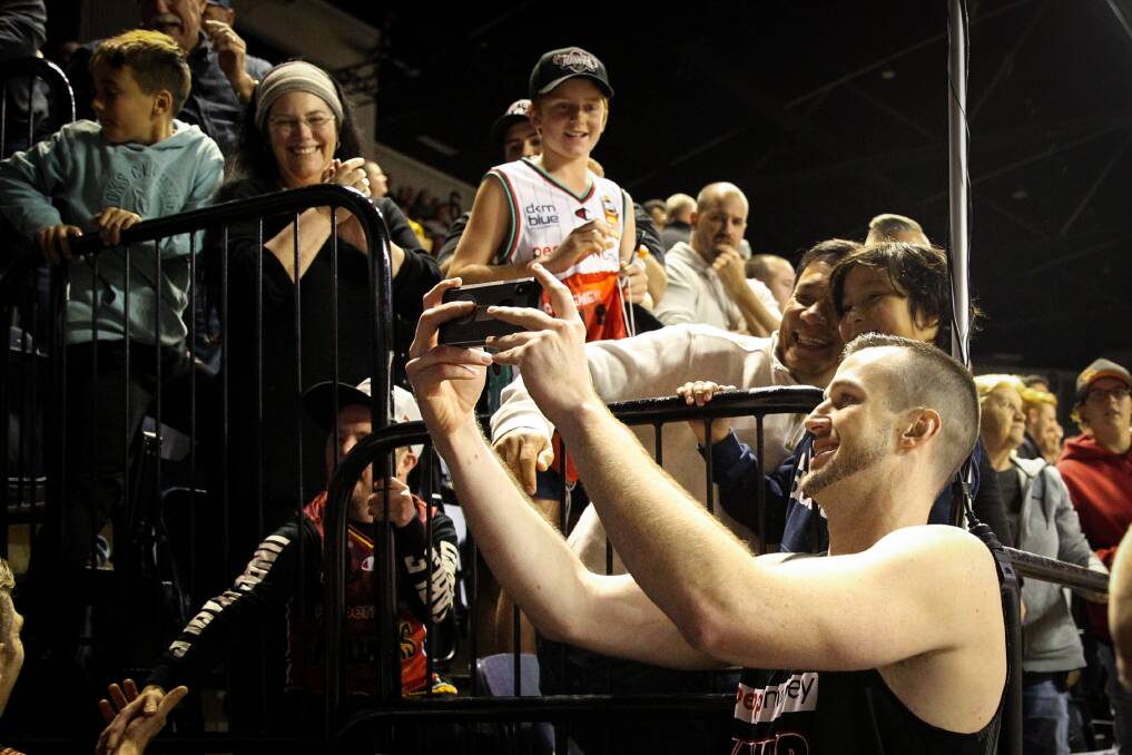 Capture the moment: AJ Ogilvy poses with fans after the Illawarra Hawks beat Perth to book their NBL playoffs spot. Picture: Anna Warr