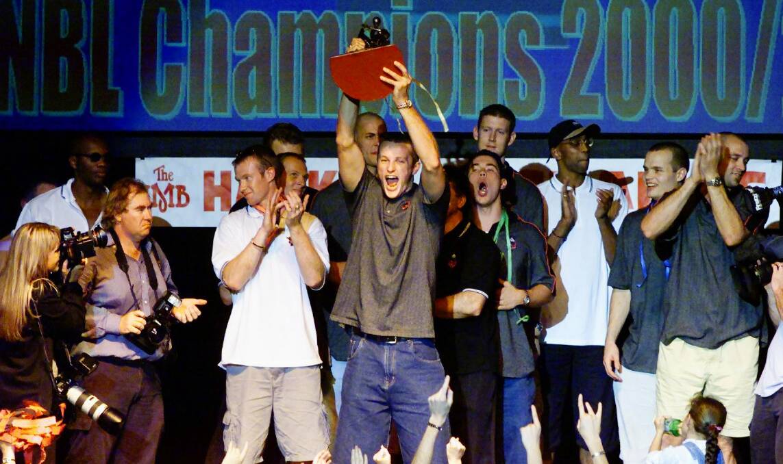 Happy days: Glen Saville lifts the 2000-01 NBL title trophy with Illawarra Hawks teammates. 