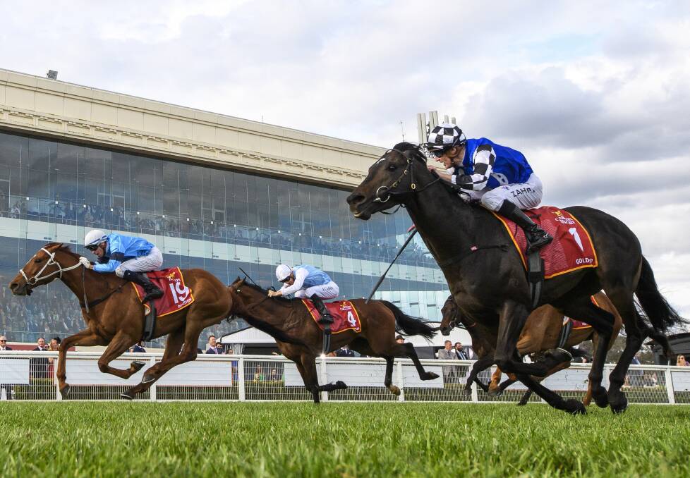 Jason Collett on Montefilia (centre) charges last as Michael Dee wins the Caulfield Cup on Durston (left), ahead of Gold Trip (Mark Zahra, right) in second. Picture by Vince Caligiuri/Getty Images
