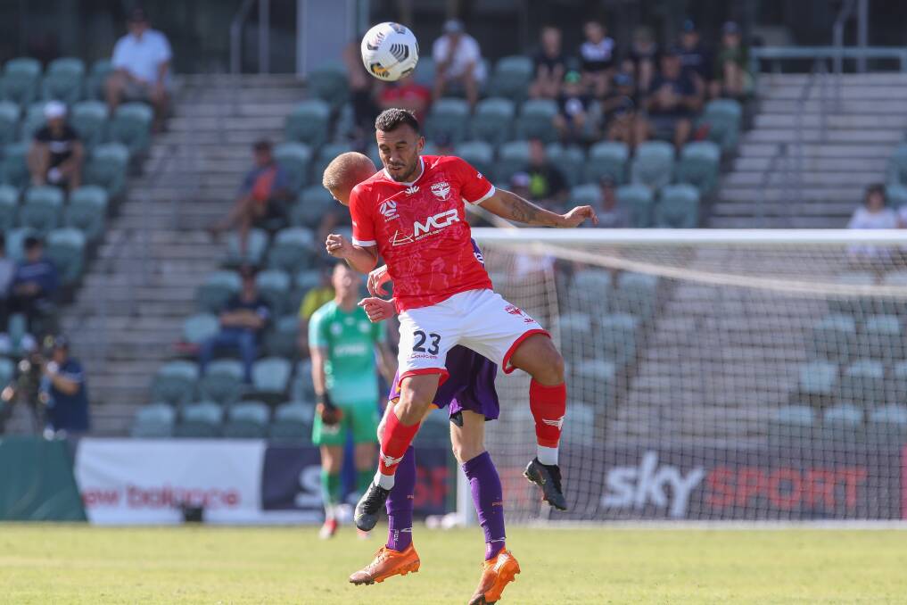 Heads up: Wellington midfielder Clayton Lewis against Perth at WIN Stadium, wearing the Wolves-inspired red shirt. Picture: Adam McLean