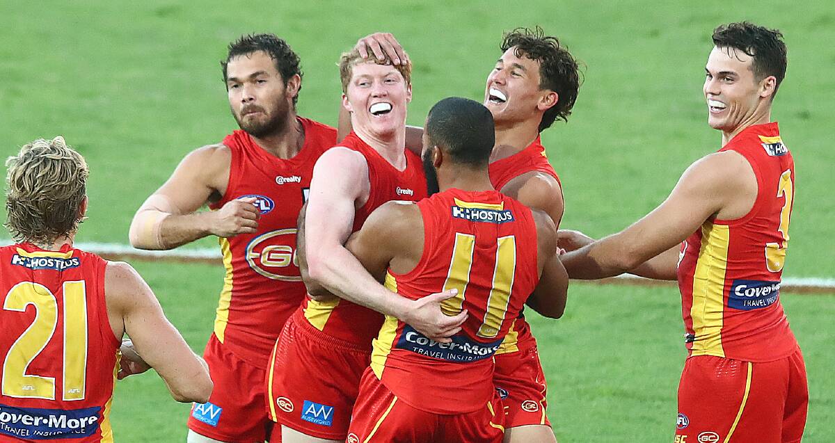 Coast to coast: Matthew Rowell (centre). Picture: Jono Searle/AFL Photos/via Getty Images