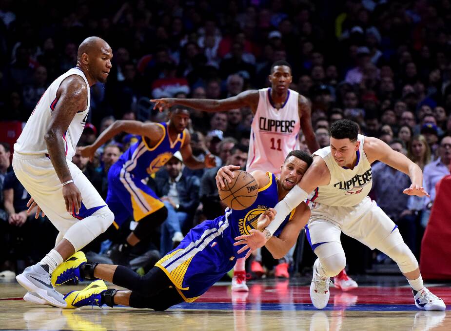 On the line: Steph Curry dives for the ball during the NBA game against the LA Clippers. Hawks general manager was at the centre of a social media storm after dressing like Curry. 