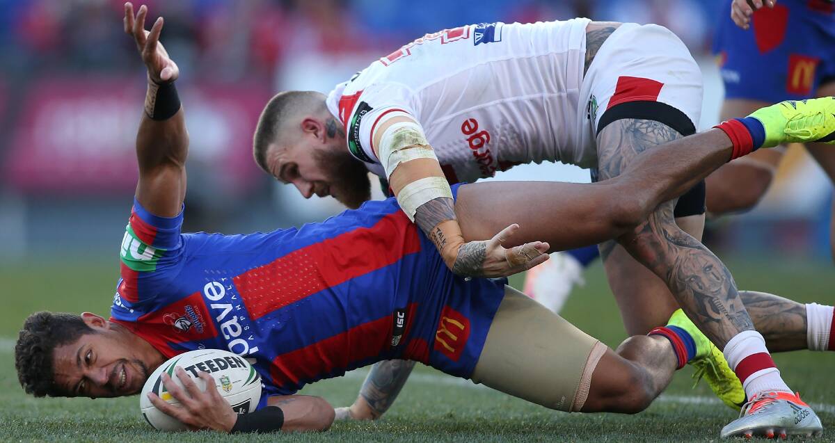 Crashing landing: Dragons fullback Josh Dugan tackles Newcastle's Dane Gagai, Queensland's try-scoring hero from Wednesday night, into the turf. Picture: Getty Images