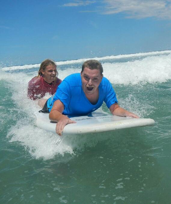 Riding the waves: Byron, who has Leigh's Disease, learning to surf on the South Coast during a holiday organised through Trusted Travel. Byron said the surf trip was the best thing he has ever done.