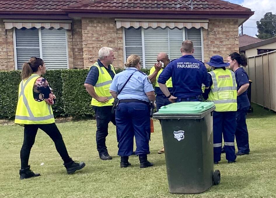 The visibly shaken truck driver addresses police and Remondis representatives after an assessment from paramedics at the crash site. Picture: Angela Thompson