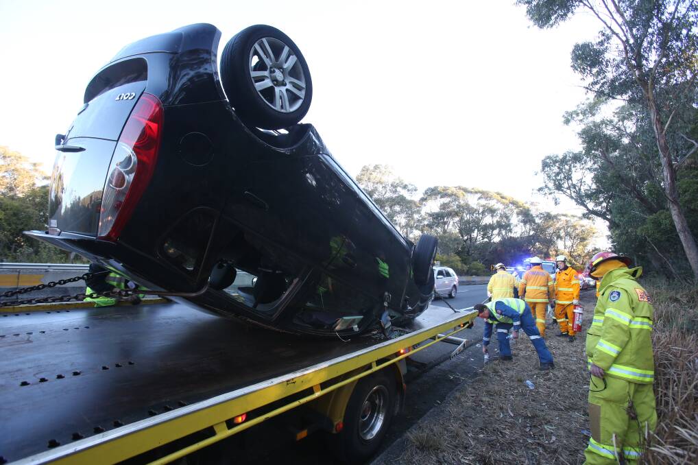 OFF COURSE: A tow truck collects the damaged car, which came to rest on its roof. Picture: Robert Peet