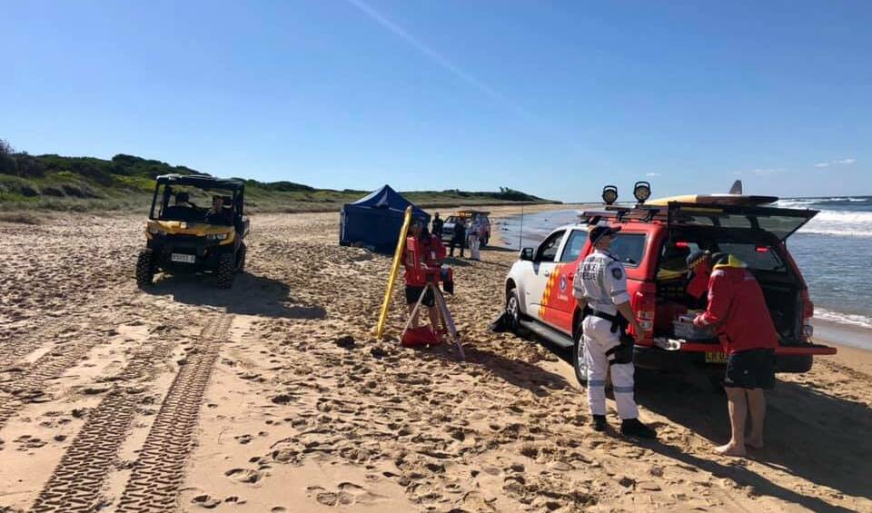 Emergency services on the sand at Corrimal, where the body of one of the deceased men washed ashore on Sunday. Picture: Surf Life Saving Illawarra