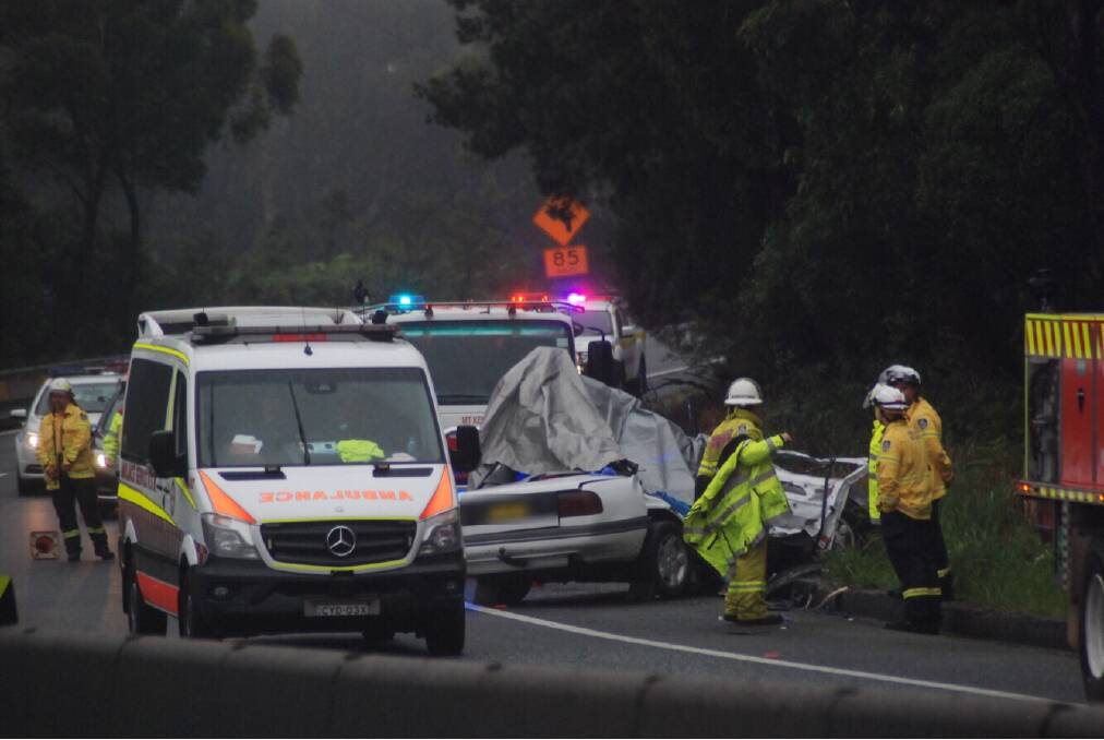 The damaged car rests in foggy conditions on the mountain as emergency services await the arrival of forensic officers. Pictures: Angela Thompson