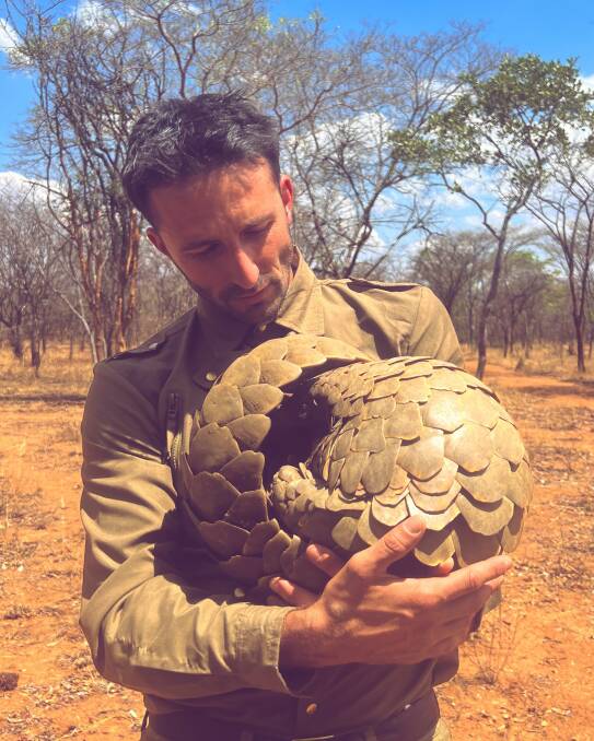 Ucles cradles a pangolin, one of three sought-after creatures he tracked down during his recent African travels. Picture: supplied 