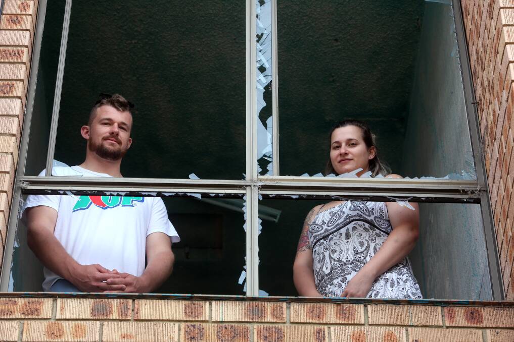 Mitch Bell and Samantha Phillips inspect damage to the apartment stairwell. Picture: Robert Peet 