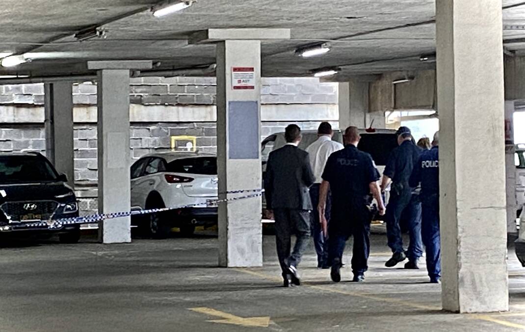 Police examine a crime scene in the carpark of the Piccadilly Centre in the shooting's aftermath. 