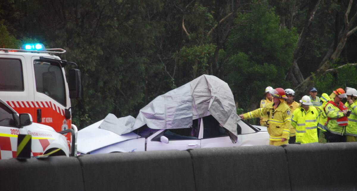 Northbound lanes of the motorway, separated by a concrete divider, are closed as emergency services work at the crash site. 