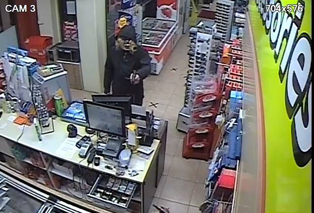 A scene from CCTV footage captured inside the service station shows the masked thief pointing a gun at attendant Joe.