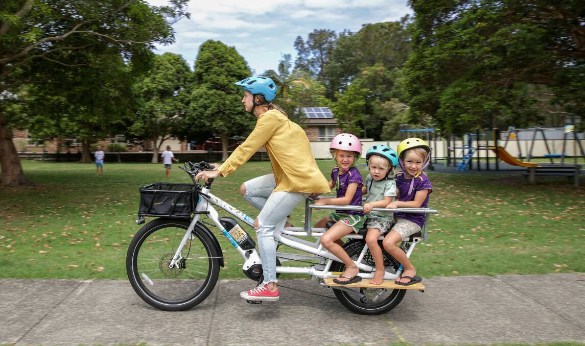 Edie, Taz and Arkie Turner hold on as mum Kristen McDonald operates the family's electric cargo bike. Picture: Adam McLean
