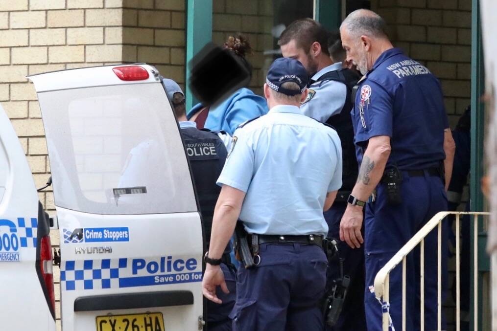 The woman is taken into a police car. Picture: Adam McLean 