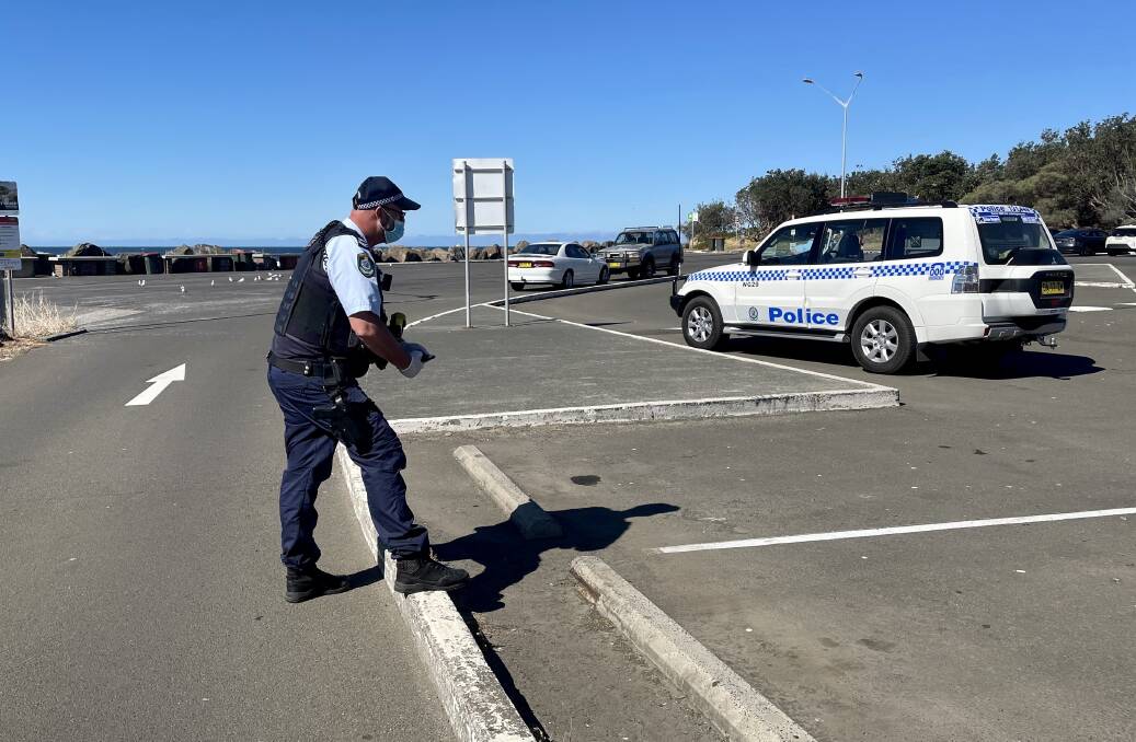 A police officer at Bellambi Boat Ramp, where the man is believed to have been stabbed. Picture: Natalie Croxon 