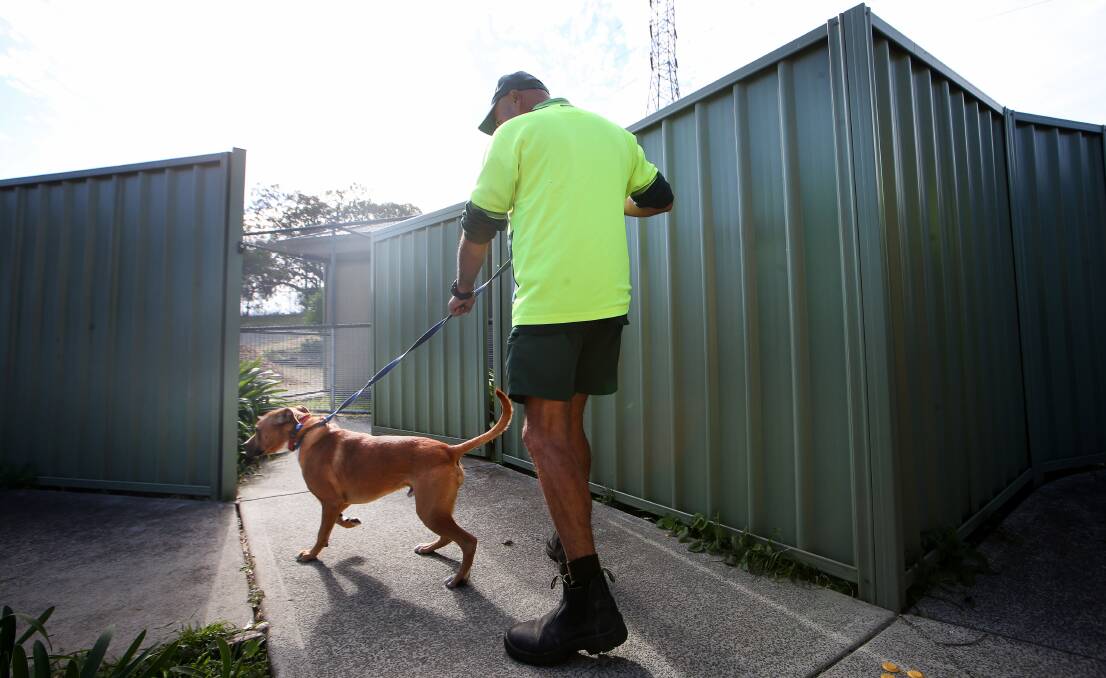 An inmate takes Milo the dog for a walk on Thursday. 