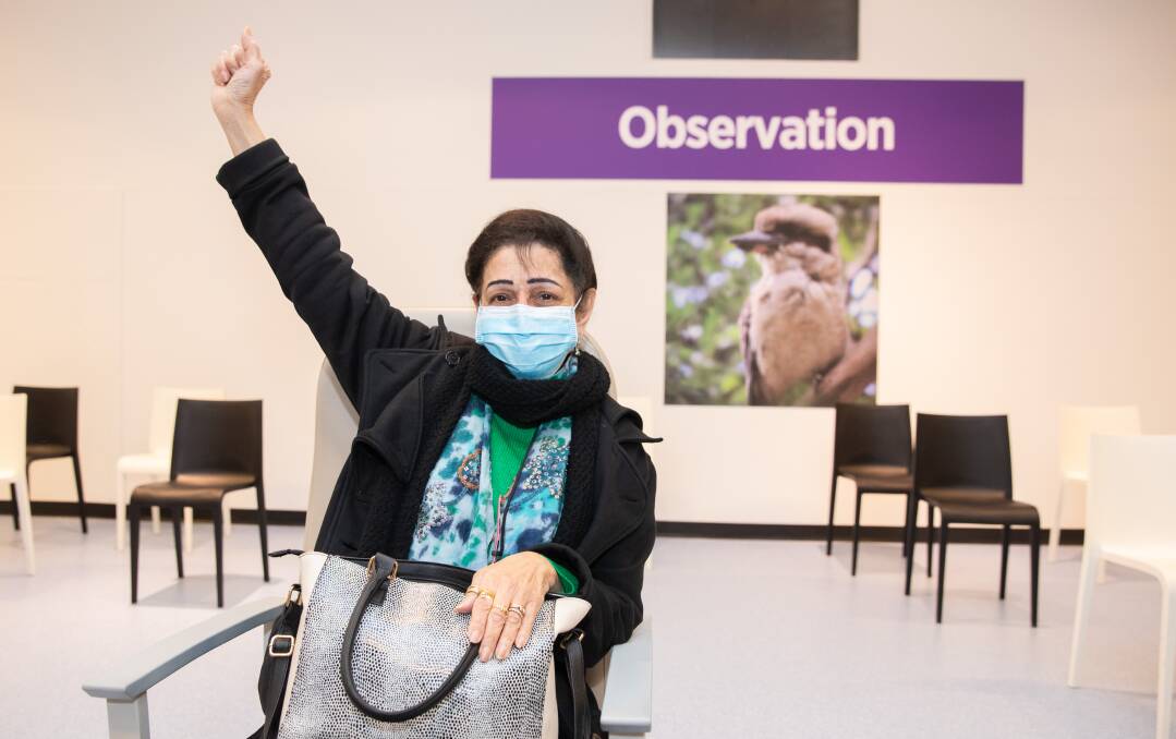 Sheila Samtani celebrates after receiving her first Pfizer dose inside Wollongong's new vaccination hub on Monday. Picture: supplied 