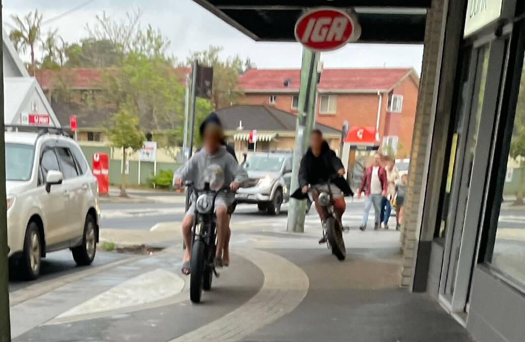 Three boys on e-motorbikes weave between pedestrians on the footpath outside Thirroul's IGA supermarket. Picture: supplied 