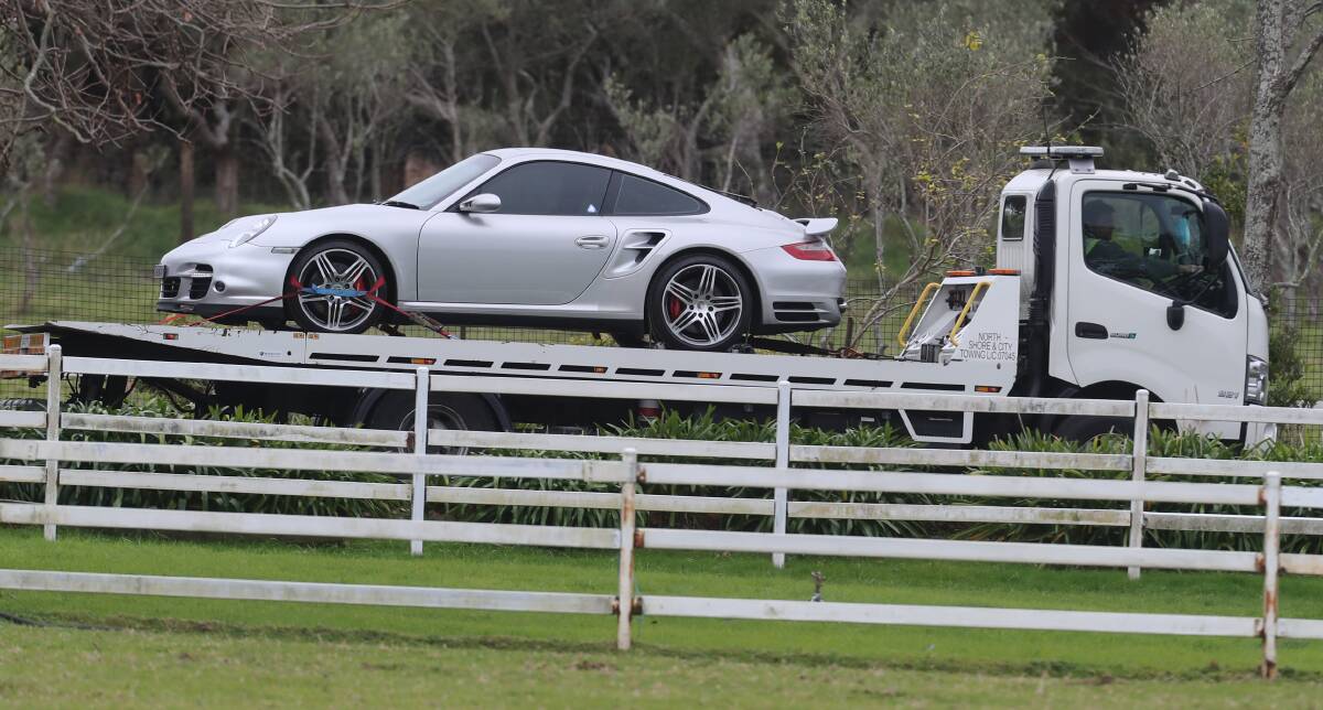 A silver Porsche departs the Helensburgh property on Wednesday. Picture: Robert Peet 
