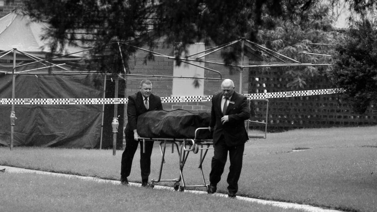 ALLEGED MURDER MYSTERY: Mark Dower's remains are escorted out of public housing complex at Mangerton on April 17, 2015. 