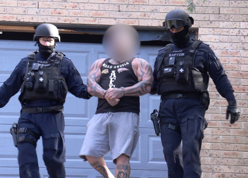 The alleged sergeant-at-arms for the Hells Angels' 'Brutal South' chapter is led from a Mollymook property Monday morning. Picture: NSW Police 