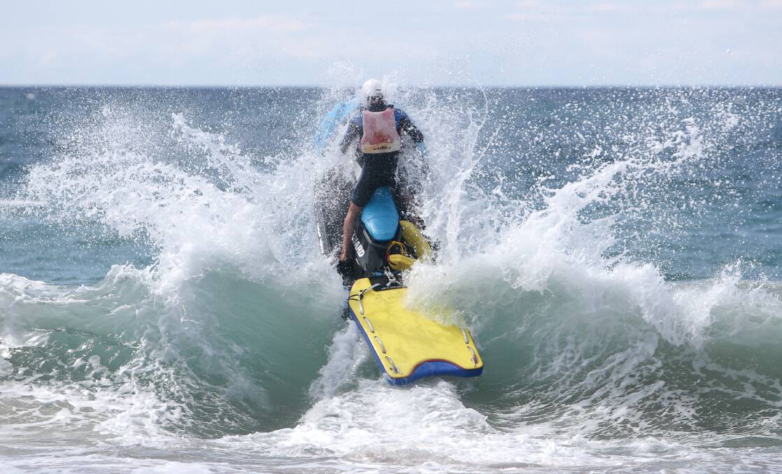 A council lifeguard hits the surf at Thurday's launch event. Picture: Adam McLean 