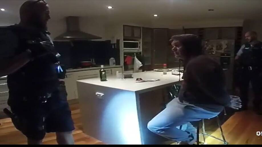 A still image taken from body worn police camera footage shows Ellis apprehended in his kitchen. 