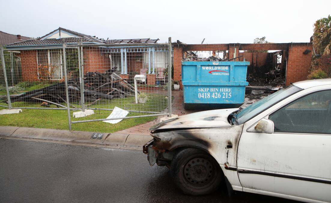 A scorched car is in the process of being removed from the badly damaged home on Wednesday. Picture: Sylvia Liber 