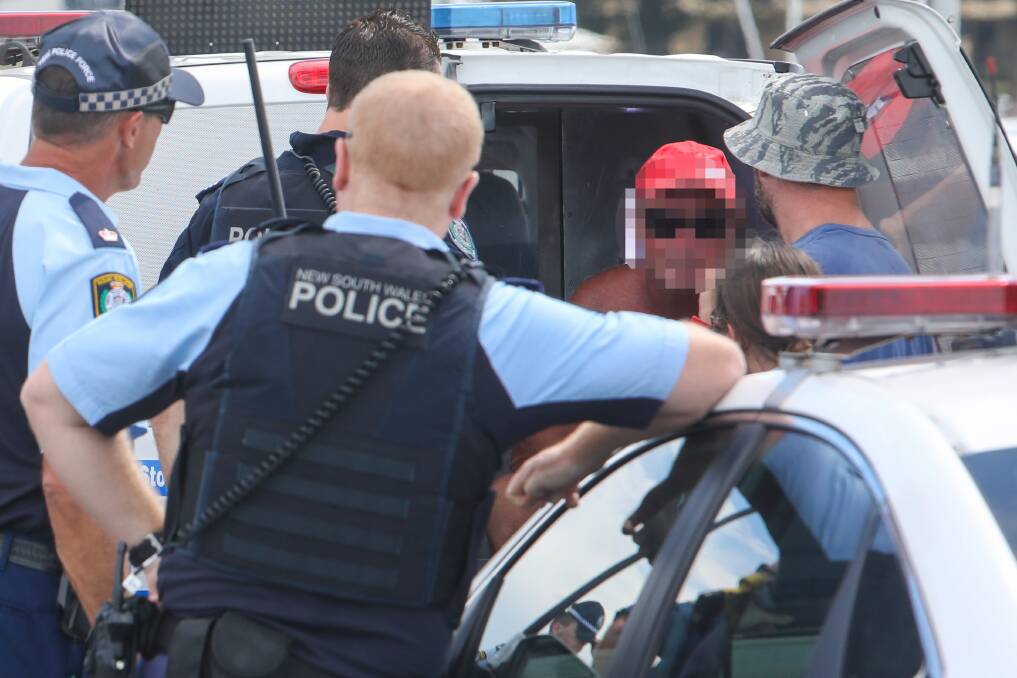 Accused and plain-clothes poilce take the man into custody at the harbour. Picture: Adam McLean 