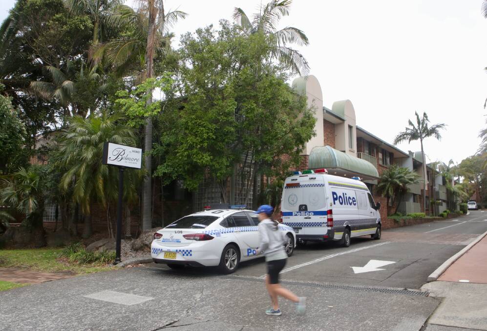 Police cars mark the entryway to the Belmore Suites on Monday afternoon. Picture: Sylvia Liber 