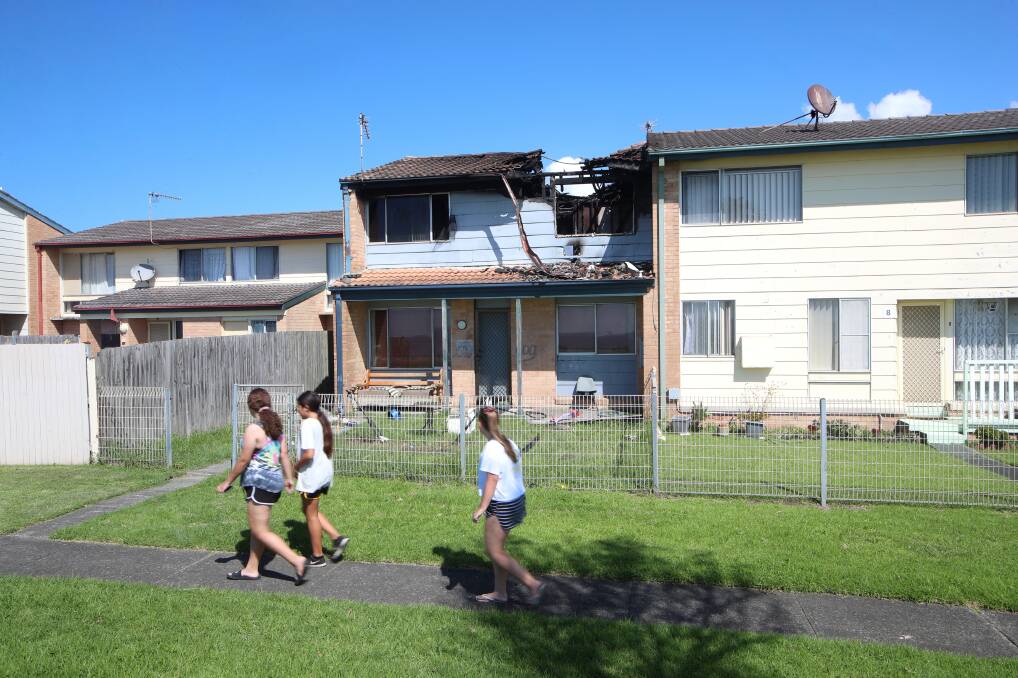 Passers-by inspect damage to the incinerated townhouse, later Monday. Picture: Sylvia Liber 