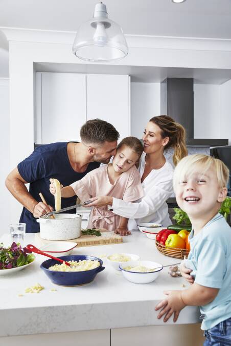 Kids in the kitchen: An image from the book featuring Beau Ryan with daughter Remi, wife Kara and son Jesse. Picture: Supplied