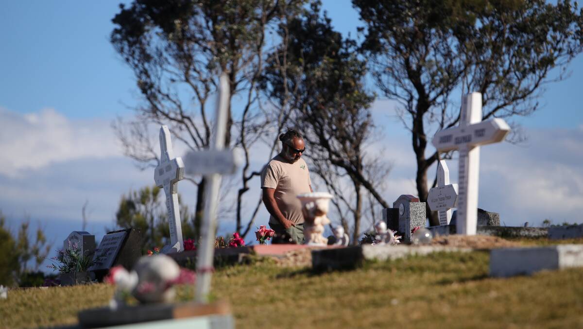 Joe McLeod-Brown, Poppy Mac's son paying his respects for loved ones in Wreck Bay. 