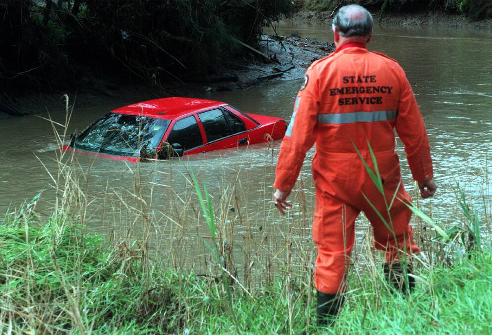 A car surfaces in Towradgi Creek after waters subside following the floods of 1998. Picture: Kirk Gilmour