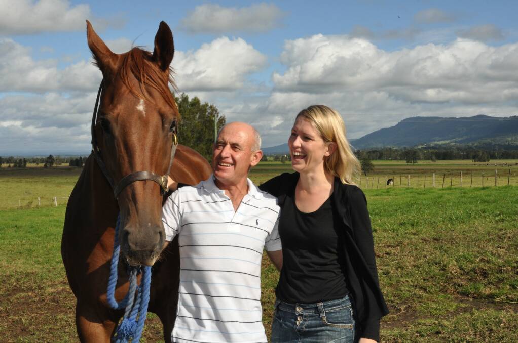 Jennifer Robinson with her father, horse trainer Terry Robinson, and a horse, at their Berry property in 2011. Picture: ADAM WRIGHT.