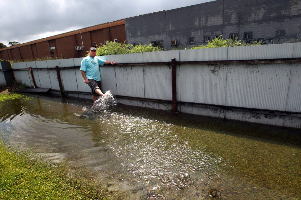 INUNDATED: Scott Johnston cleans up his Kembla St place after flooding in 2012.