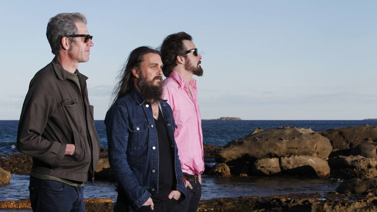 TUMBLEWEED: Lenny Curley, Paul Hausmeister and Richie Lewis on the rocky point of City beach Wollongong. Lewis says they're still dealing with the death of their bass player but are 'open' to new adventures. Picture: Andy Zakeli