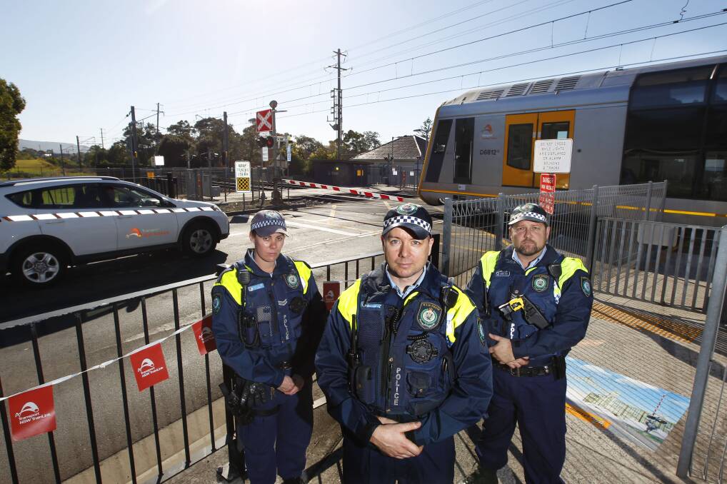 Don't do it: Police Transport Command officers at the Woonona level crossing where people race across the tracks in front of trains. Picture: Anna Warr
