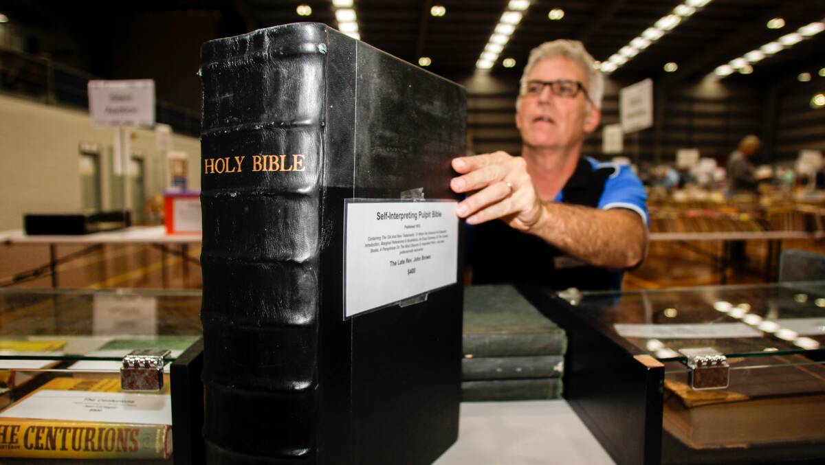 On the line: Lifeline South Coast executive director Grahame Gould with the centrepiece of this weekend's book fair, the 1813 Self-Interpreting Bible by the Reverend John Brown. Picture: Georgia Matts