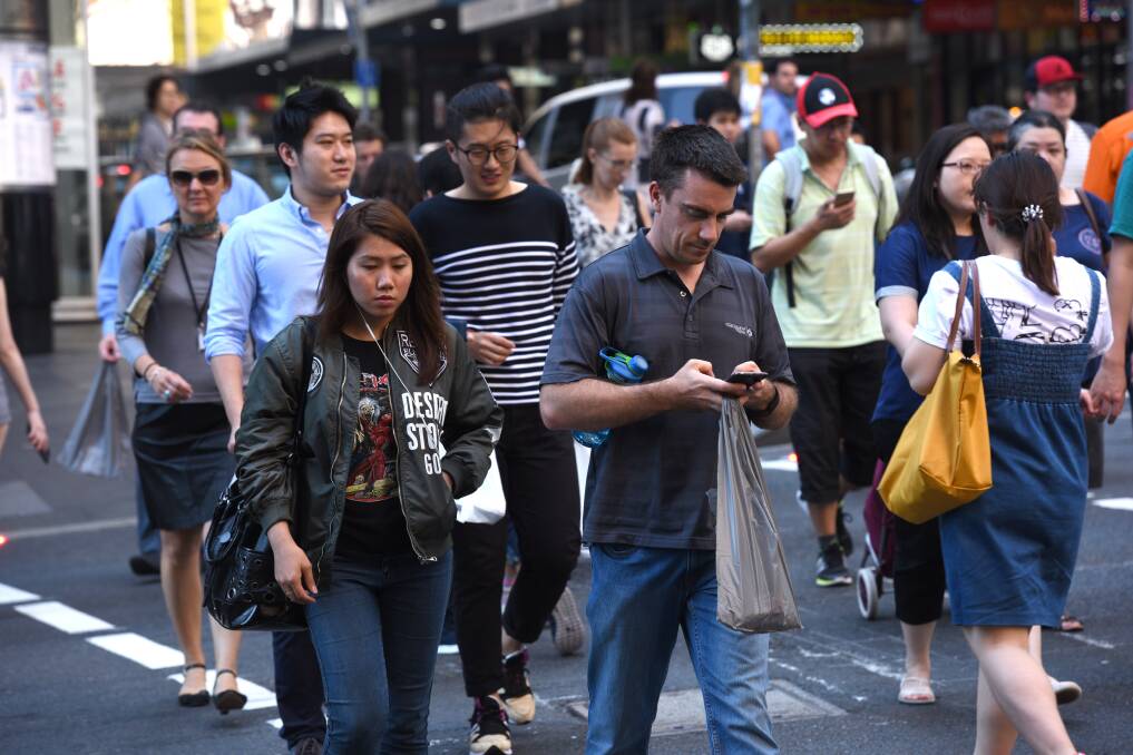 Too many people are crossing roads while looking down at their phones according to an NRMA study. Picture: Steven Siewert
