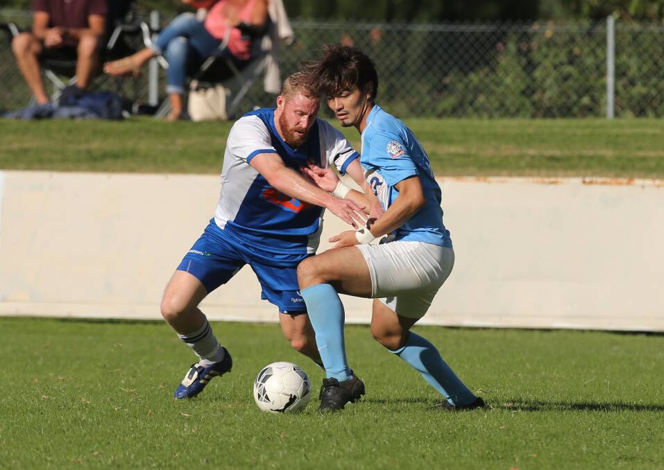 BATTLE: Tarrawanna's Darren Stone and Wollongong Olympic's Yuseke Ueda battle for possession on Saturday. Picture: Robert Peet