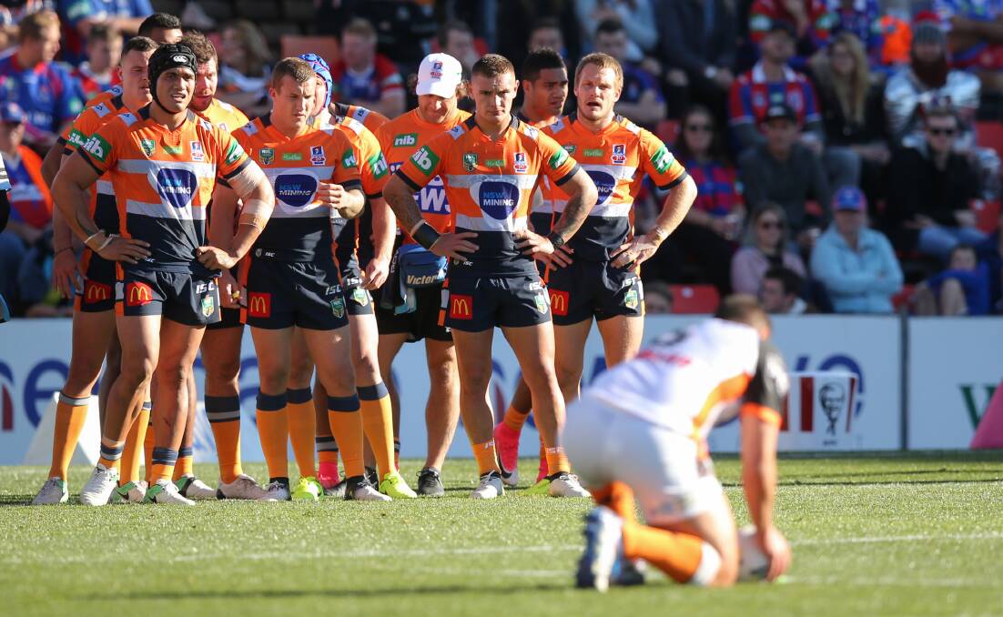 Tough times: Knights players watching on as Tigers' Tuimoala Lolohea lines up a conversion kick. Picture: Max Mason-Hubers