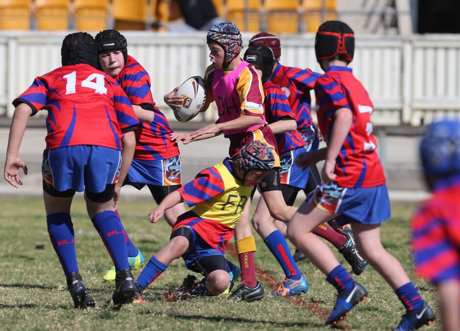 Surrounded: Shellharbour's Riley Moran takes on the Wests defence in the 11 years division two grand final.