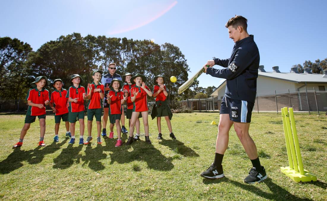 Catch: Peter Nevill (back) and Nic Maddinson (right) with Woonona East Primary School students. Picture: Adam McLean