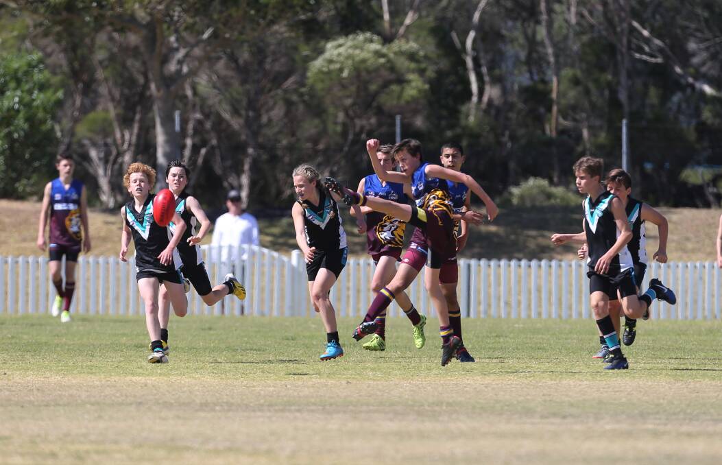 Kicking clear: Wollongong's Elan Sewell in the under 13 grand final. Pictures: Robert Peet
