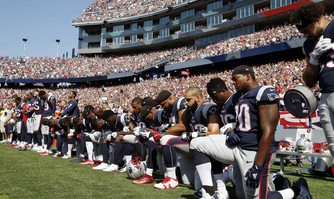PATRIOTS: Members of the New England team kneel during the anthem before a game last September. This would now draw fines.