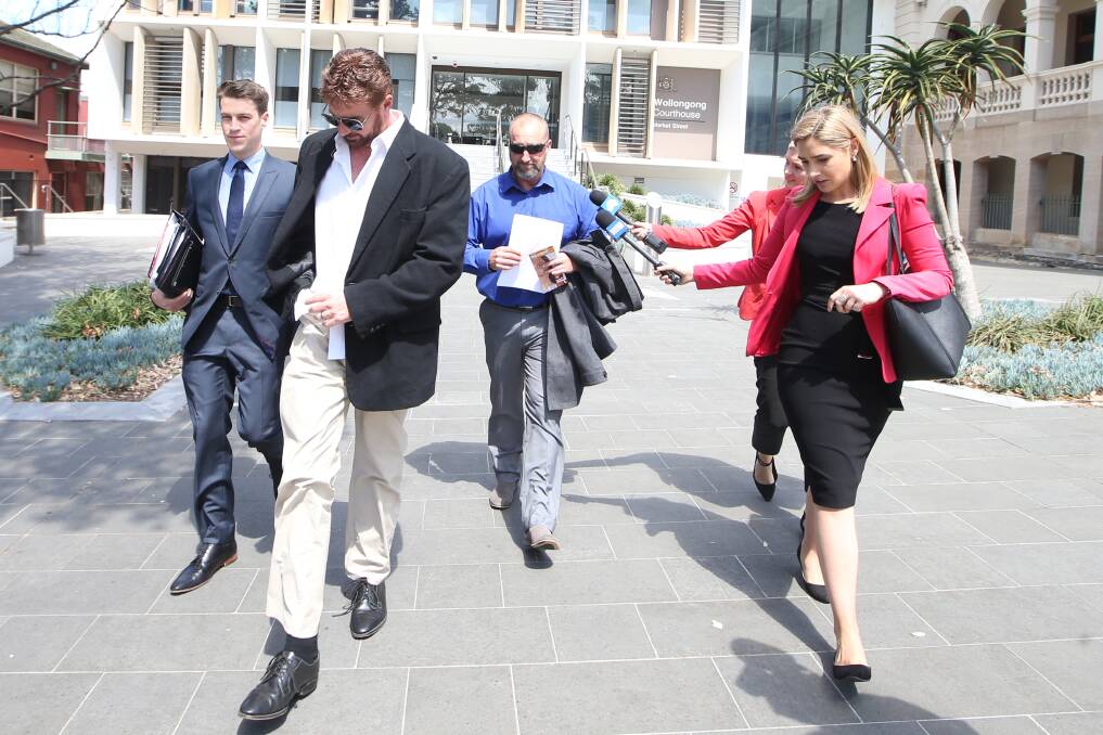 Disgraced former cop Jason Hall (centre), refuses to speak to media outside Wollongong courthouse after being convicted of using money stolen from colleagues used to fund his pokie habit.