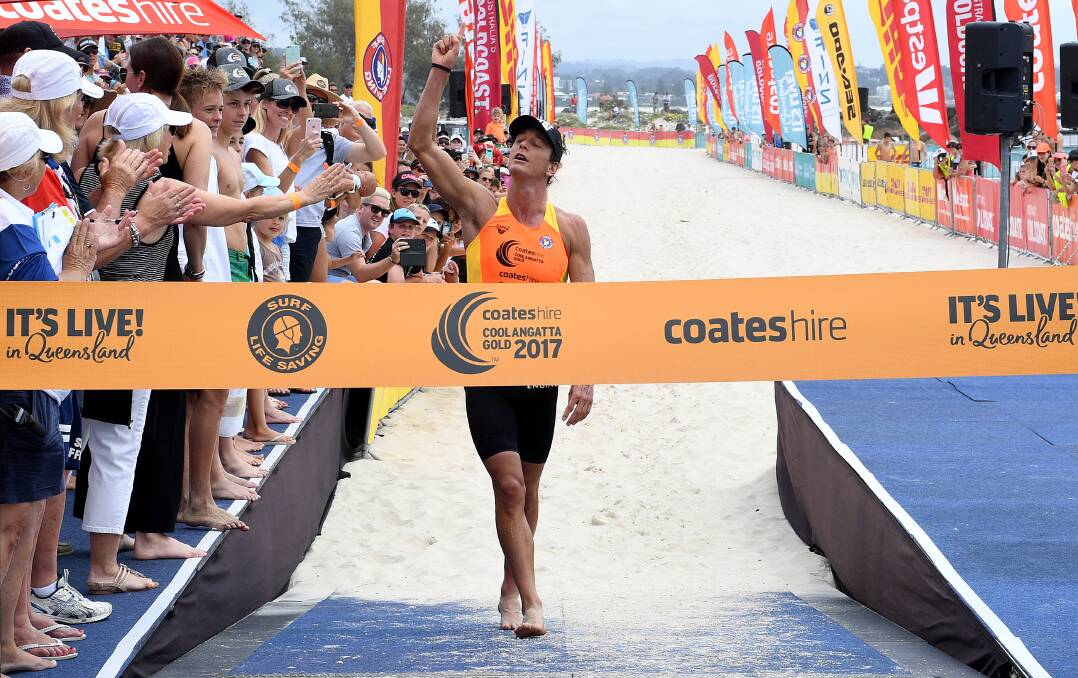 Tribute: Ali Day before crossing the line to win the Coolangatta Gold on Sunday. Picture: AAP Image/Dave Hunt