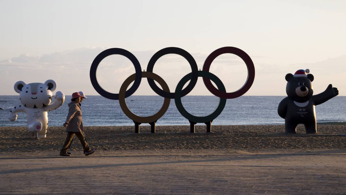 People walk past the Olympic rings and statues of the 2018 PyeongChang Winter Olympic Games mascot Soohorang, left, and Bandabi, right. Picture: SeongJoon Cho/Bloomberg Winter olympics